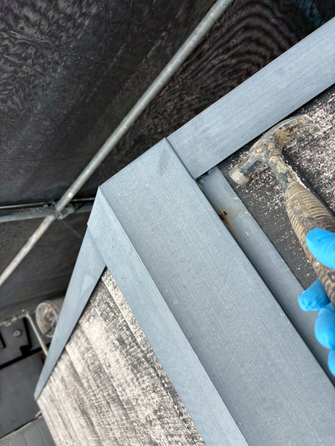 京都伏見区正木建装の西京区屋根塗装前に板金の釘を金槌で修繕