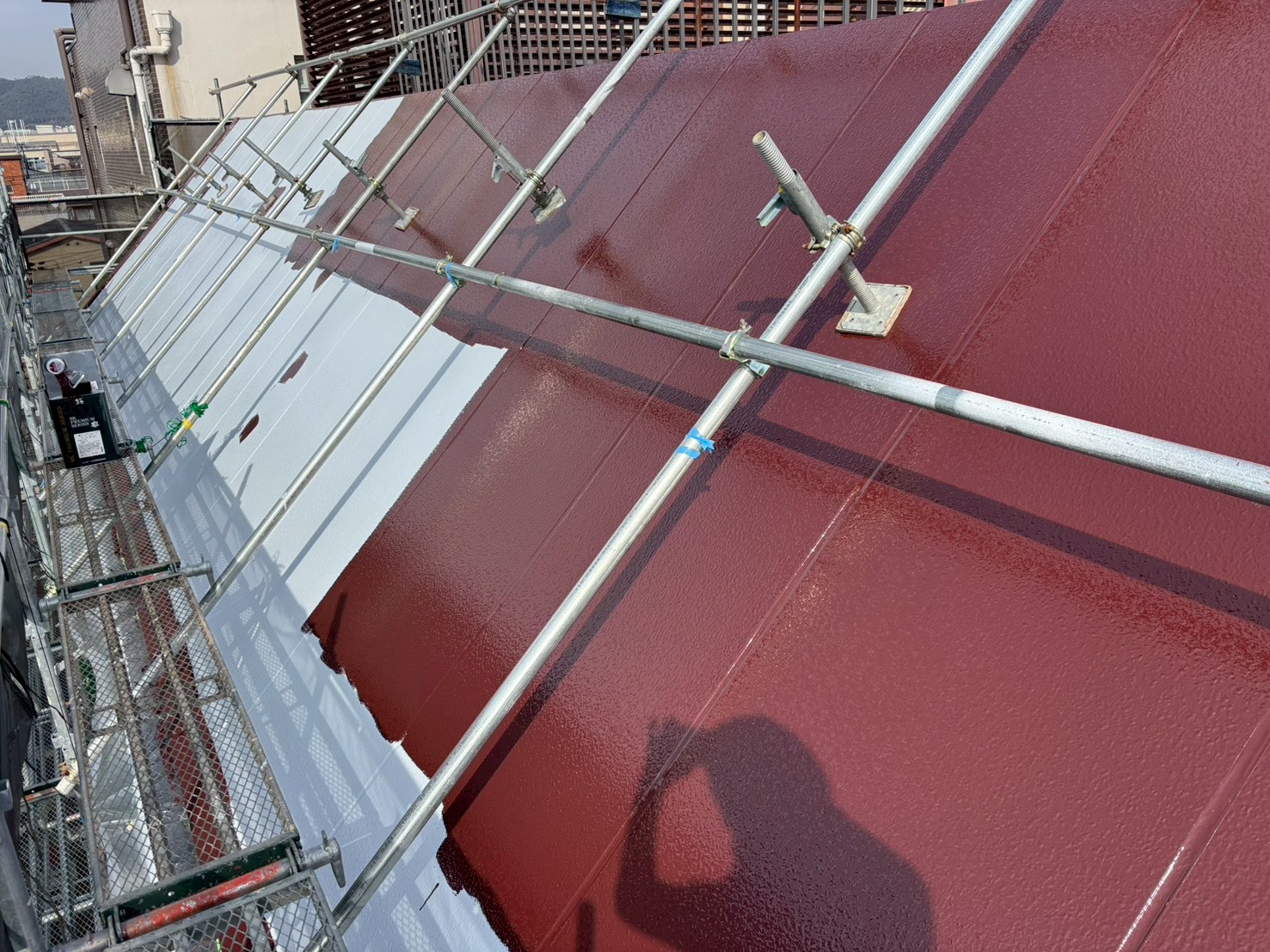 伏見区正木建装が、破風屋根にシリコン塗料中塗り作業2